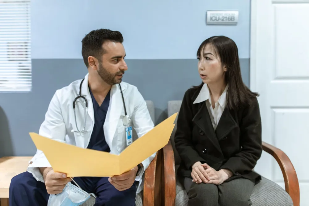 Patient speaking with a doctor at a clinic about flu COVID or cold symptoms