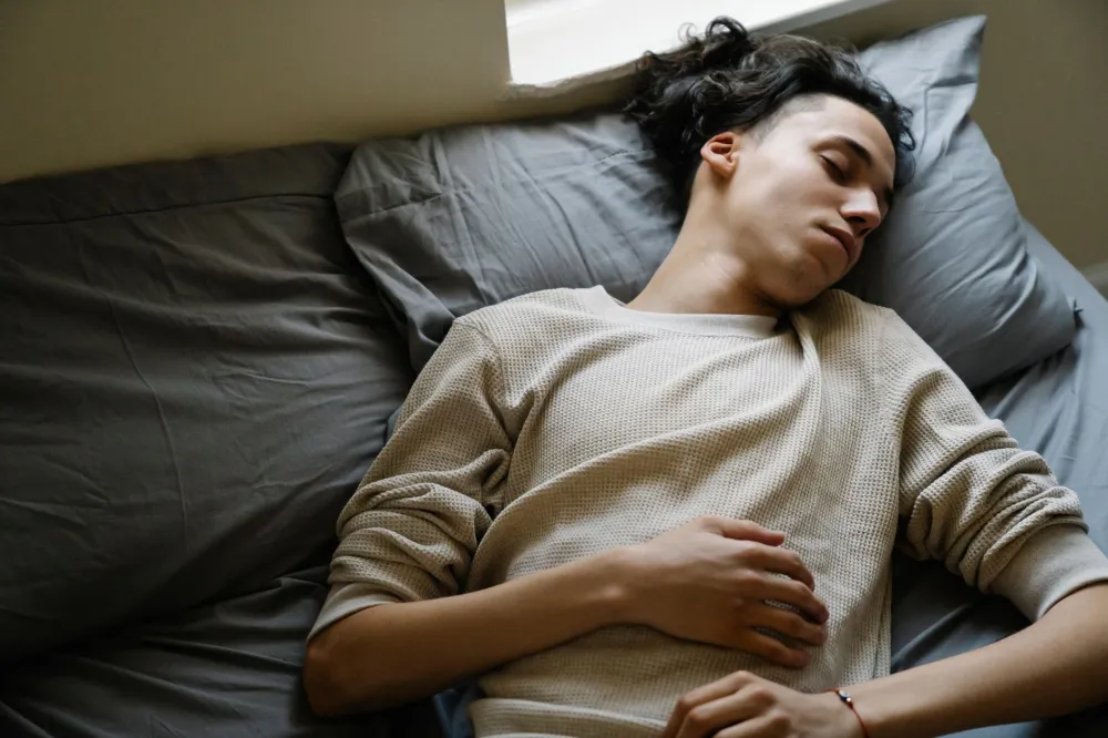 Teenager sleeping soundly in bedroom getting healthy recommended hours of sleep