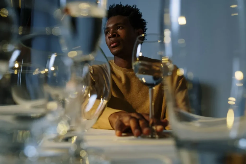 Person thoughtfully holding a glass of wine considering light drinking and brain health effects