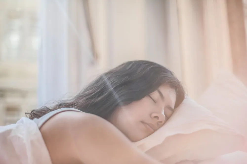 Light Drinking & Brain Health: What the Research Really Says 4 Woman sleeping soundly in a dark bedroom supporting overnight brain repair and memory consolidation