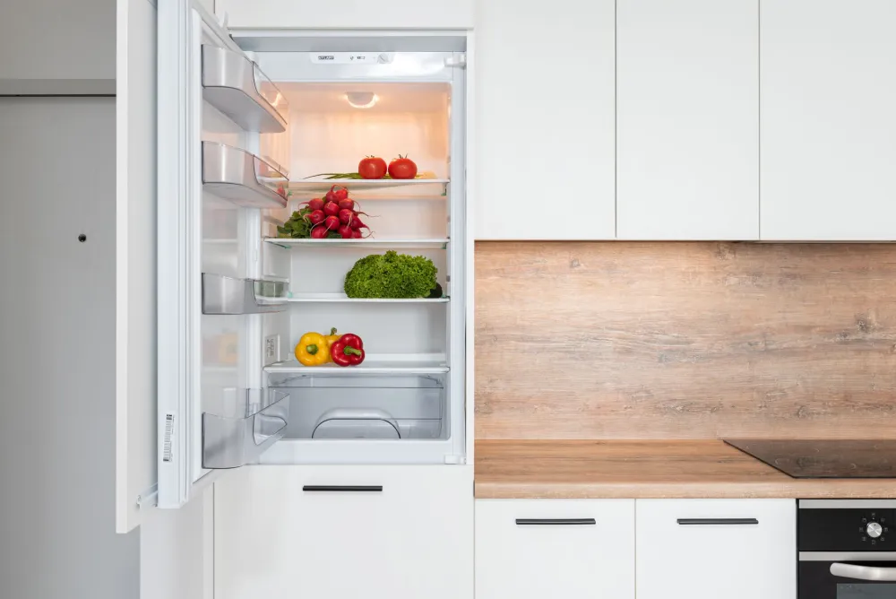 Organized refrigerator shelves with prepped healthy foods stored in clear containers