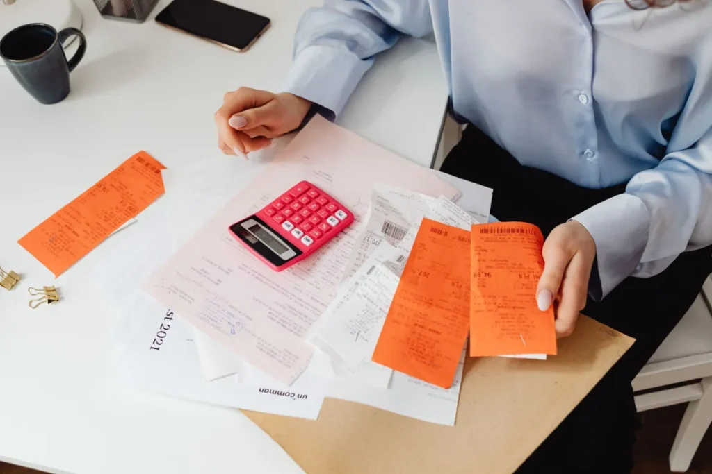 Person sitting at desk reviewing medical bills and health insurance documents