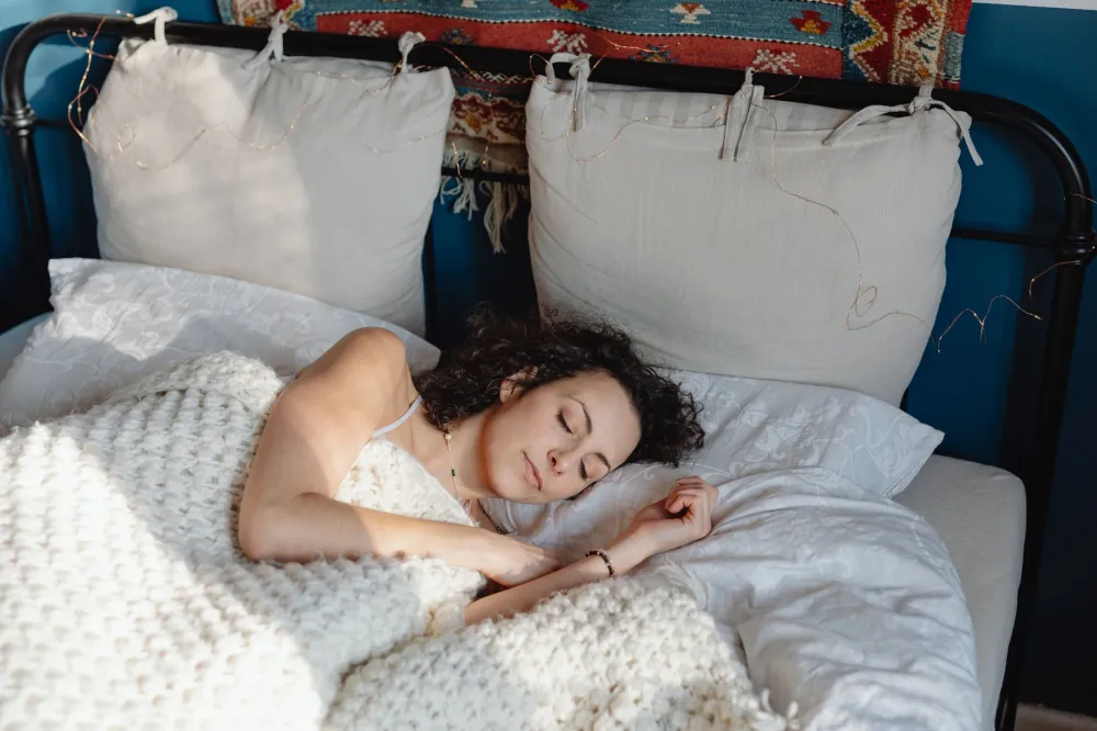 Woman sleeping comfortably in bedroom with correct pillow supporting neck alignment