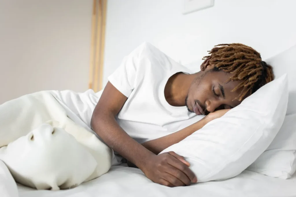 Person sleeping peacefully in bed, representing REM sleep and disease risk reduction