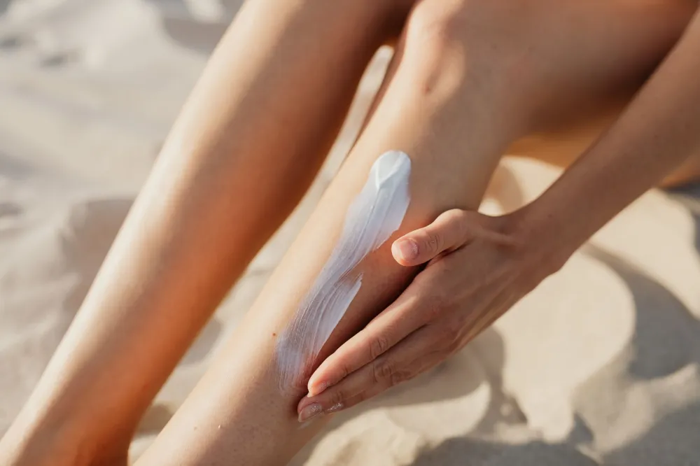 Person applying SPF sunscreen to face outdoors to protect skin while using retinol