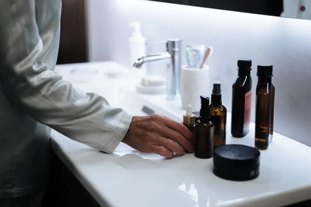 woman arranging skincare products in the correct order on a bathroom counter