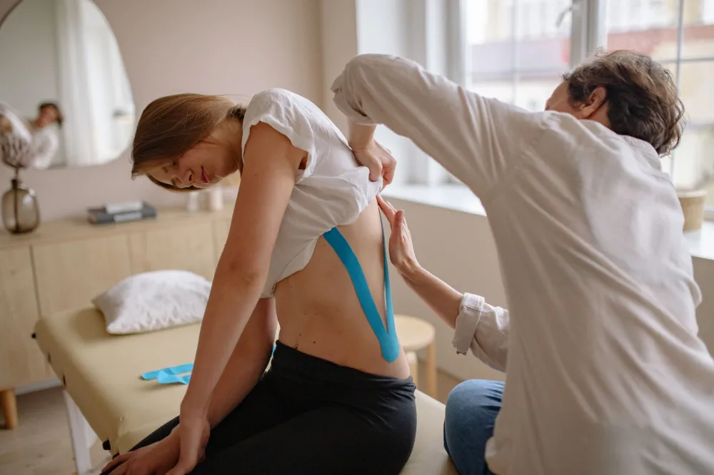 Physical therapist guiding patient through a lower back stretch for sciatica relief
