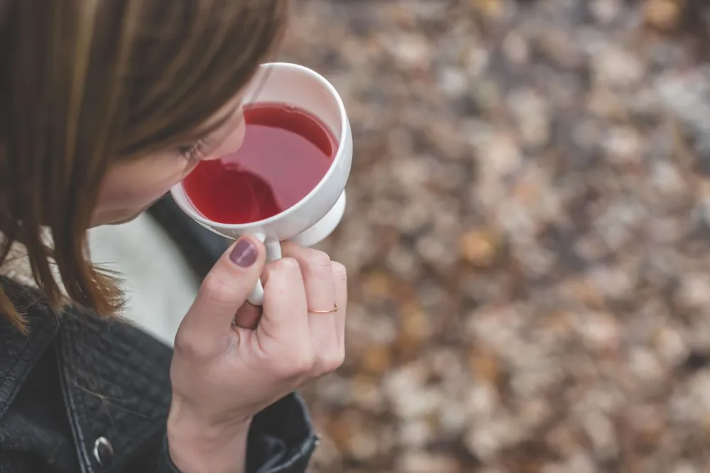 Woman drinking warm herbal tea to soothe sinus pressure and nasal congestion