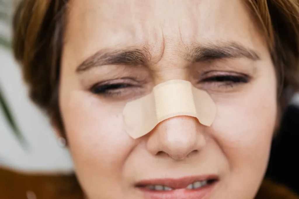 Sinus Congestion Remedies That Actually Help 25 Woman holding her nose and sinuses in discomfort from sinus congestion