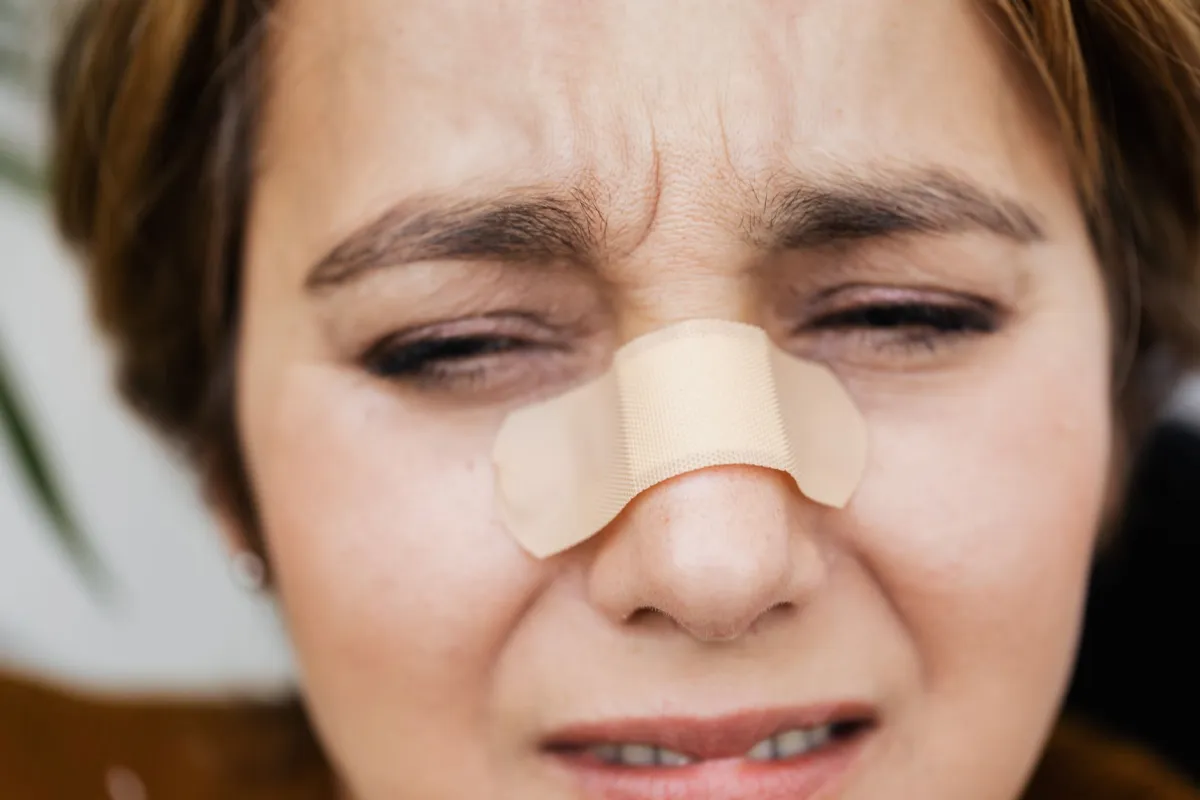 Woman holding her nose and sinuses in discomfort from sinus congestion