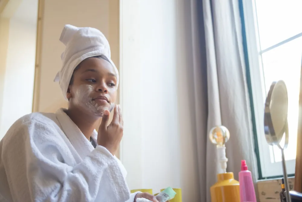 Woman applying thick moisturizer to her face to support skin barrier repair