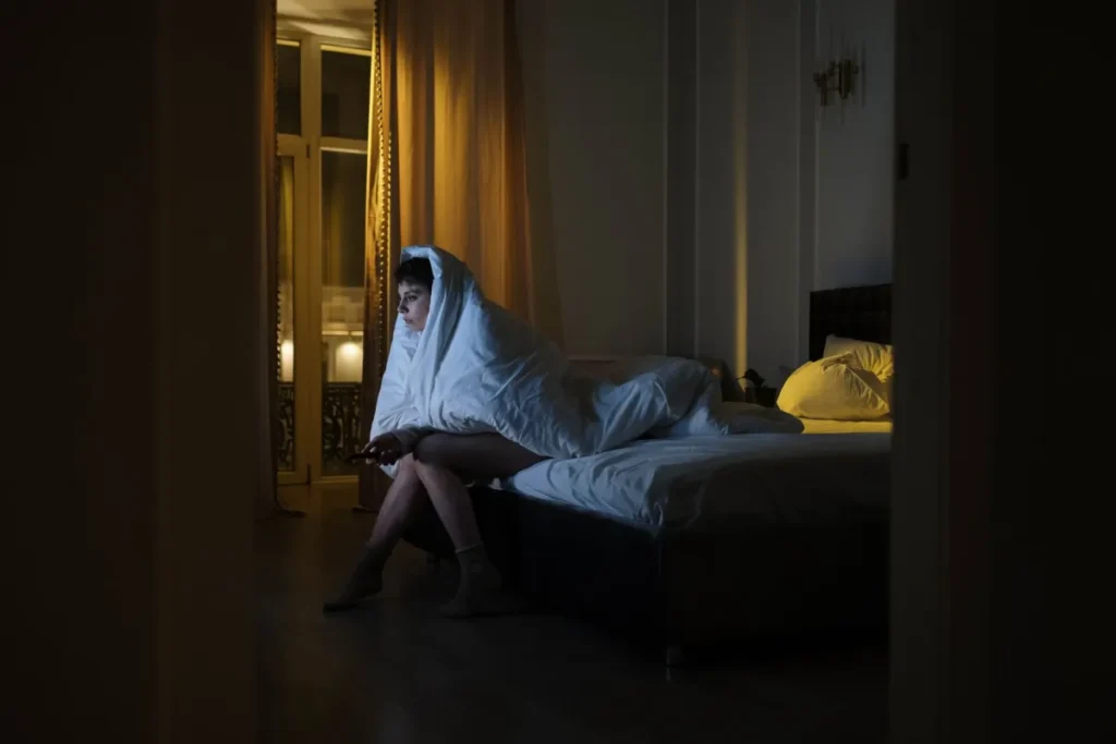 Person lying awake at night, sleep and stress affecting weight loss efforts