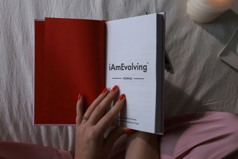 Woman writing in a wellness journal, planning her own healthcare and self-care routine