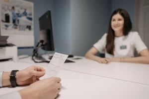 Woman reviewing healthcare documents at home, representing the hidden labour women shoulder navigating healthcare