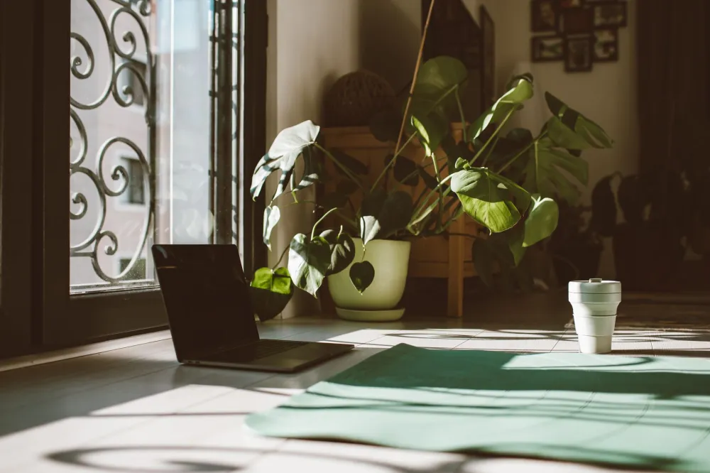 Yoga for Complete Beginners at Home: What Actually Works 2 A rolled-out yoga mat with props on a wooden floor ready for a beginner home session