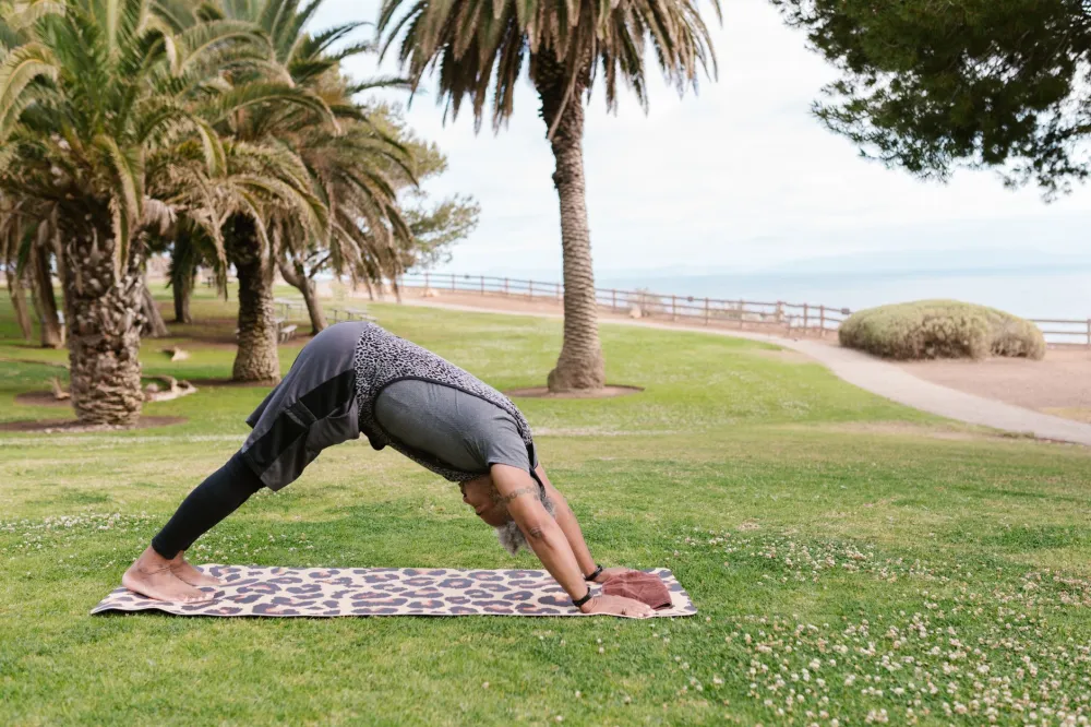 Yoga for Complete Beginners at Home: What Actually Works 4 Person in downward-facing dog pose on a yoga mat during a beginner home yoga practice