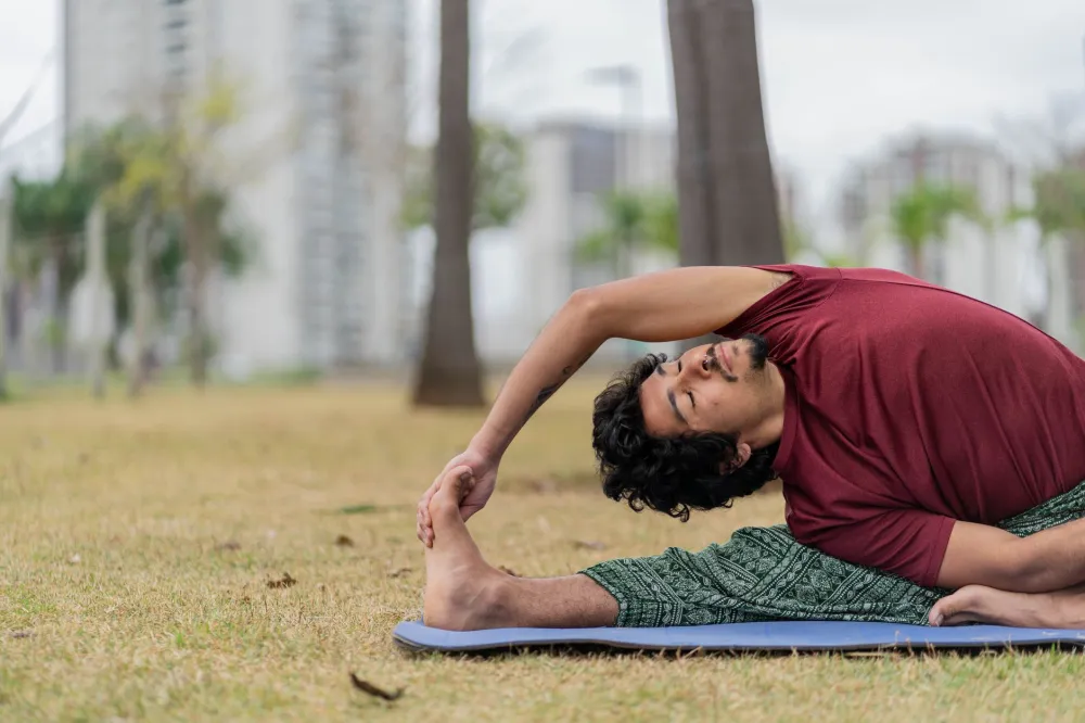 Yoga Poses That Ease Lower Back Tension: What Works 4 Man lying on floor doing supine spinal twist yoga pose for back relief