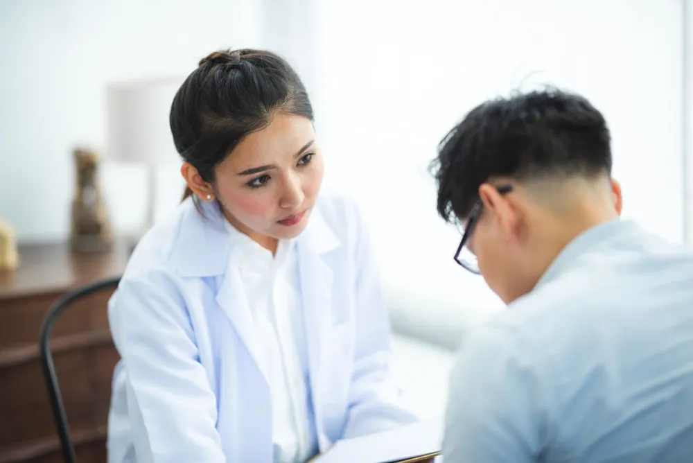 Woman talking to a doctor about persistent breast pain before her period