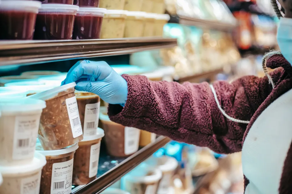 Woman reading nutrition label in grocery store to identify hidden added sugars