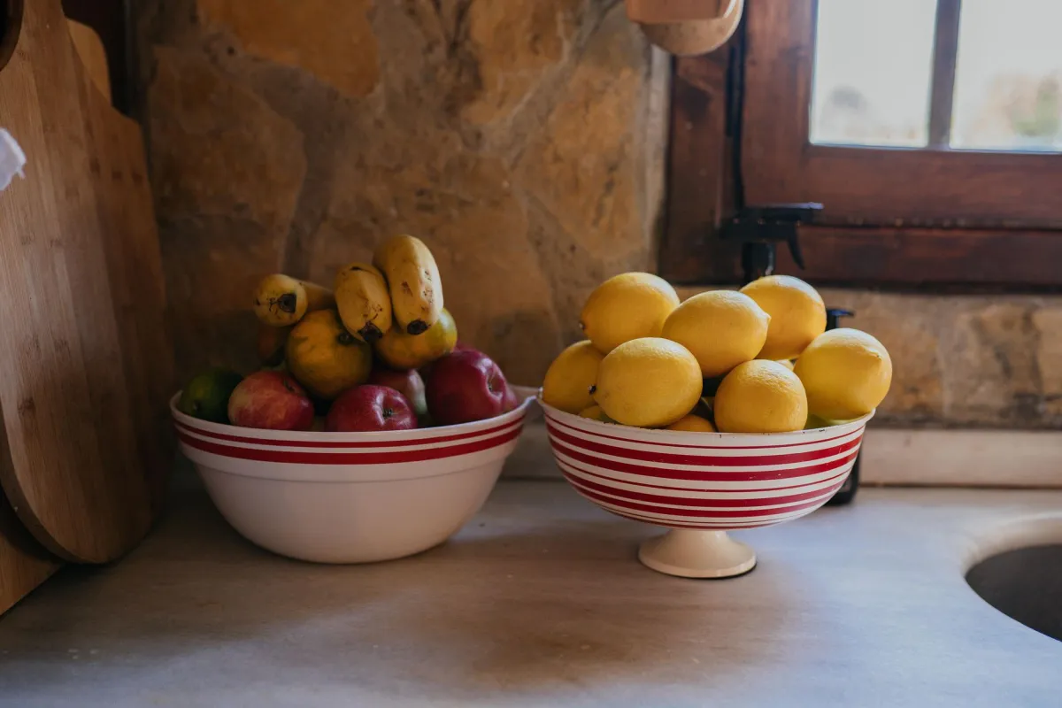 Colorful fruit bowl on kitchen counter showing natural alternatives to added sugar