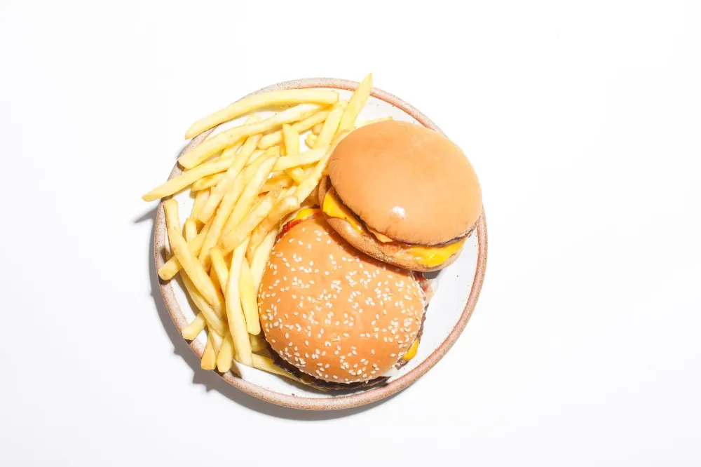 Dirty keto vs clean keto contrast showing processed fast food on a tray