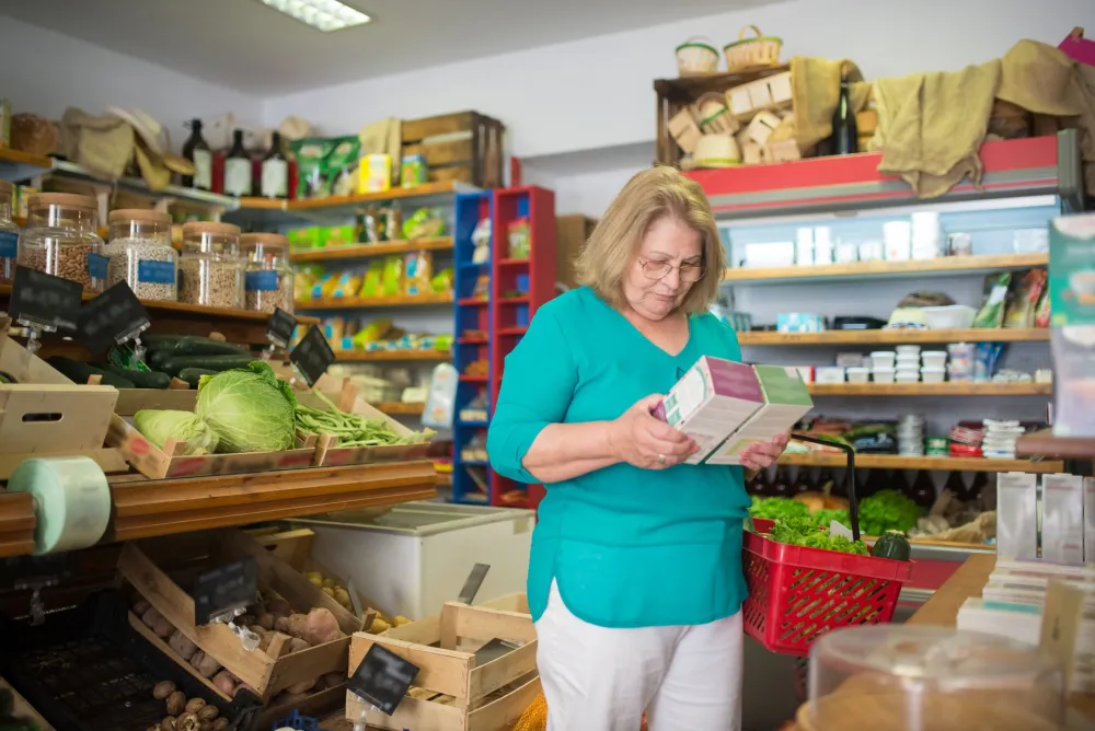 Woman reading a nutrition label to track net carbs on a keto diet plan
