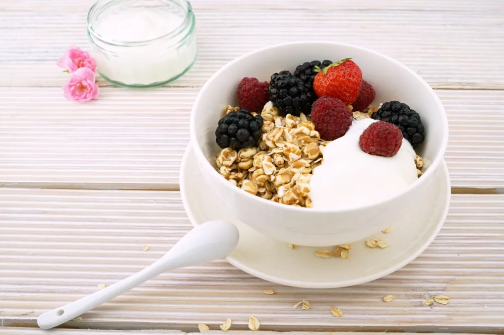 Bowl of plain Greek yogurt with berries, an easy high-protein food for small appetites