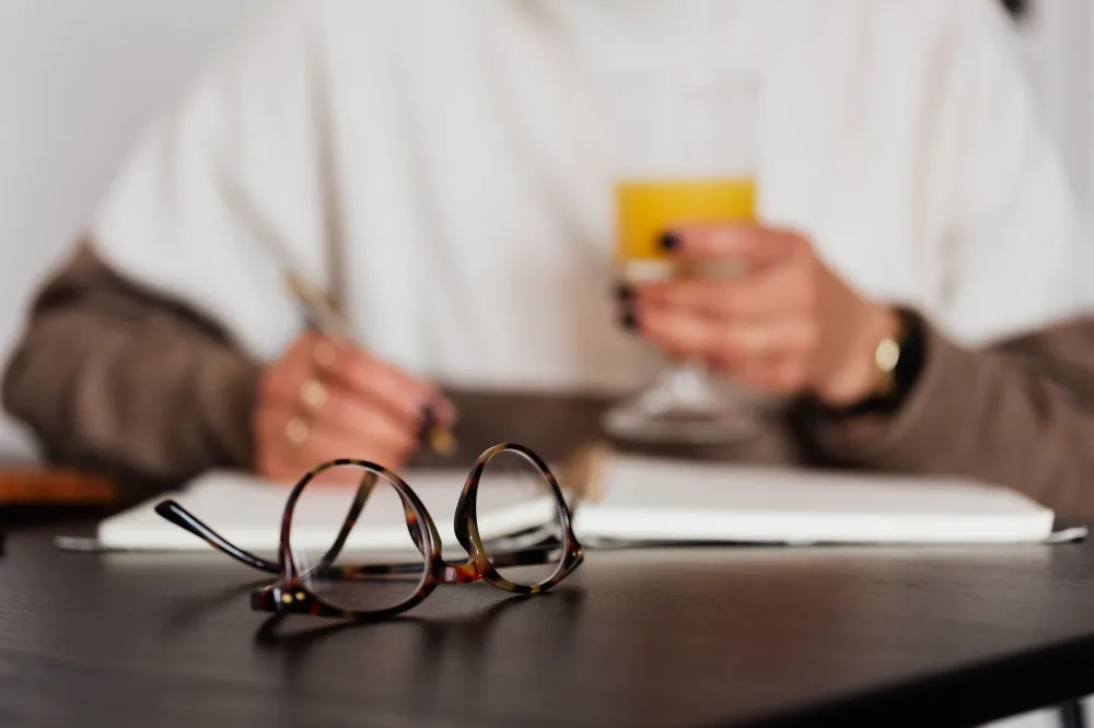 Woman writing in a food journal to track daily protein intake while taking GLP-1 medication