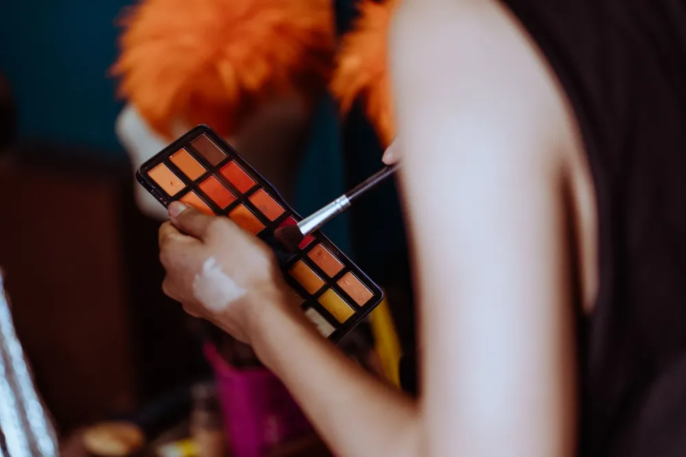 Color corrector palette and makeup sponge used to hide a hickey on the neck
