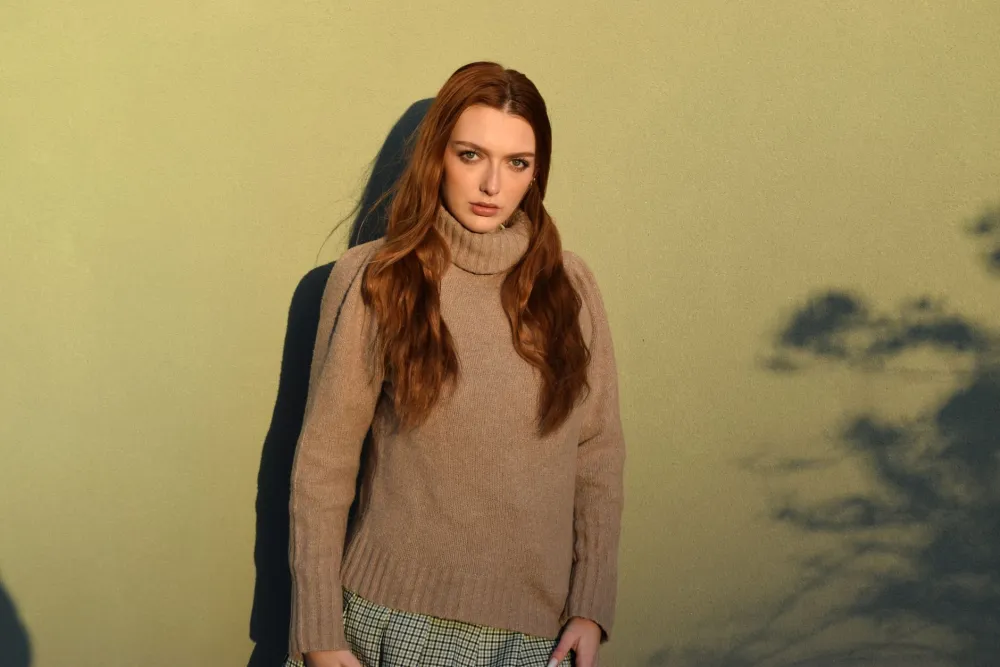 Smiling woman in a cozy turtleneck sweater that covers her neck completely