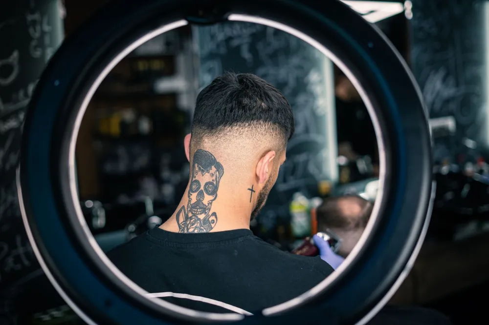 Man checking a fading bruise on his neck in a bright bathroom mirror
