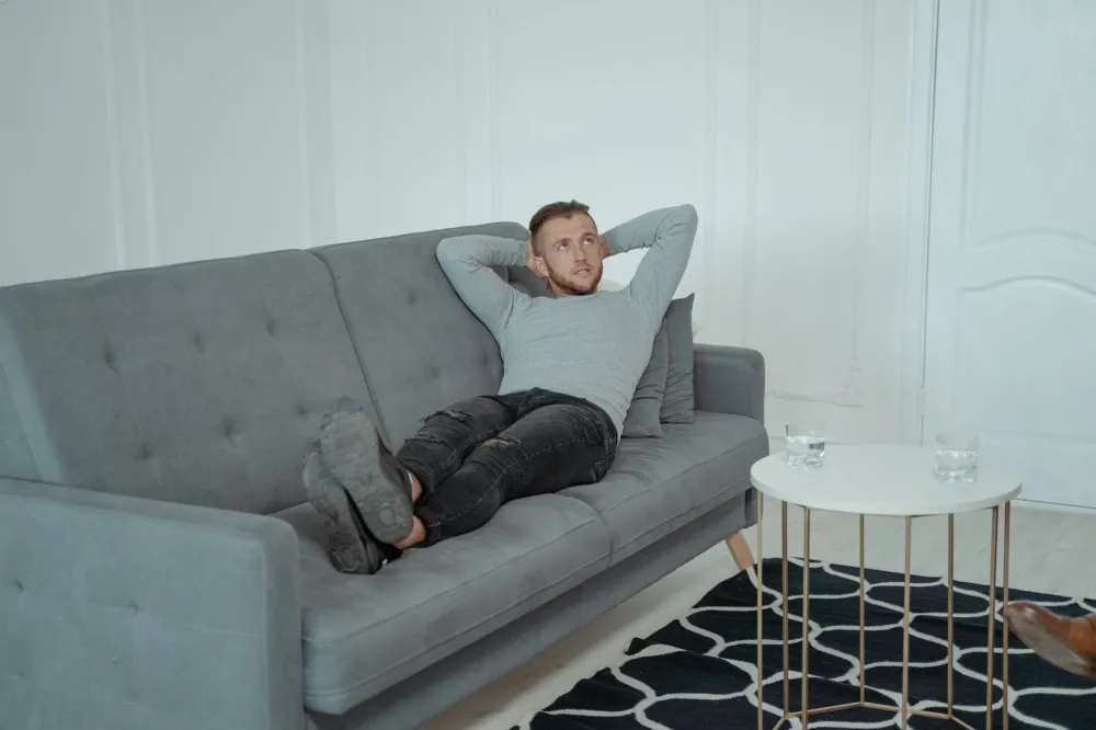 Person resting with leg elevated on couch pillow to reduce bruise swelling