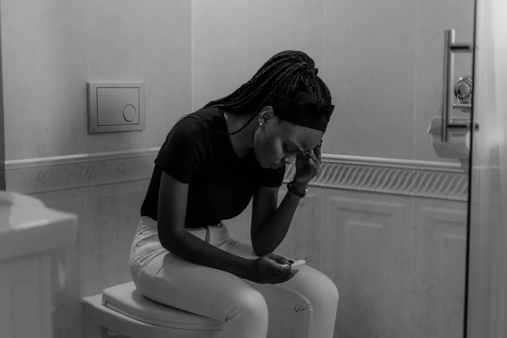 Woman holding a home pregnancy test after noticing early pregnancy bleeding spotting