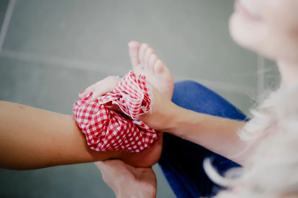Hands applying a warm compress cloth to skin for soothing an ingrown hair or pimple