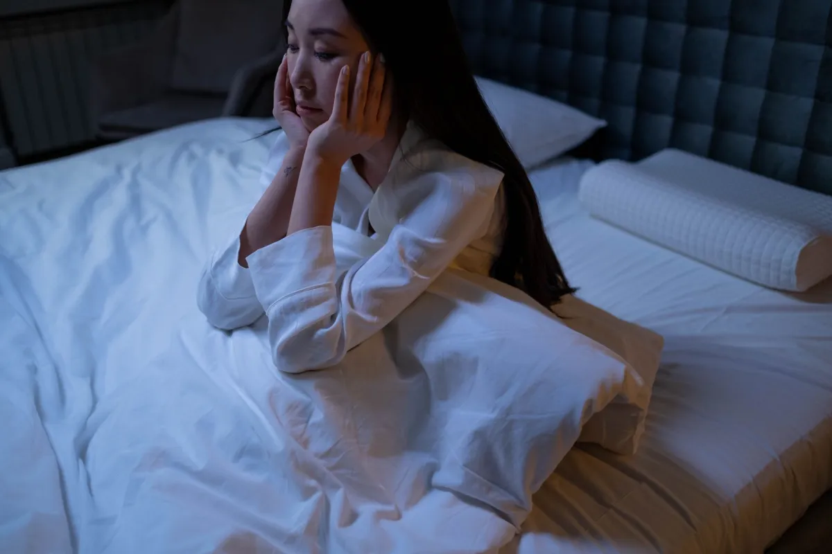Person lying awake at night struggling with chronic insomnia and poor sleep quality