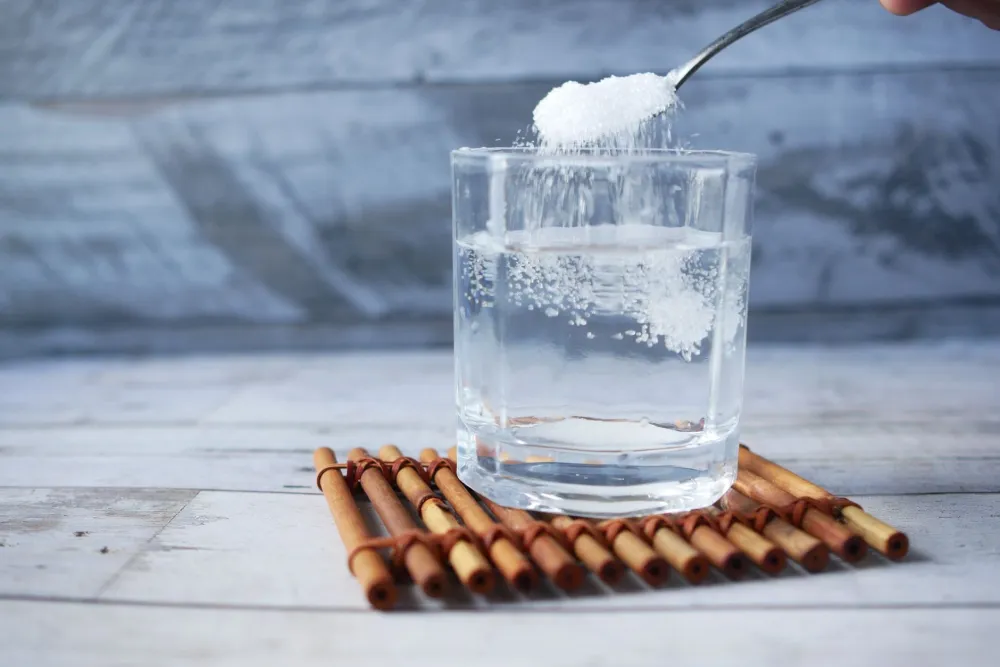 Person drinking a glass of water with electrolytes to relieve keto flu symptoms