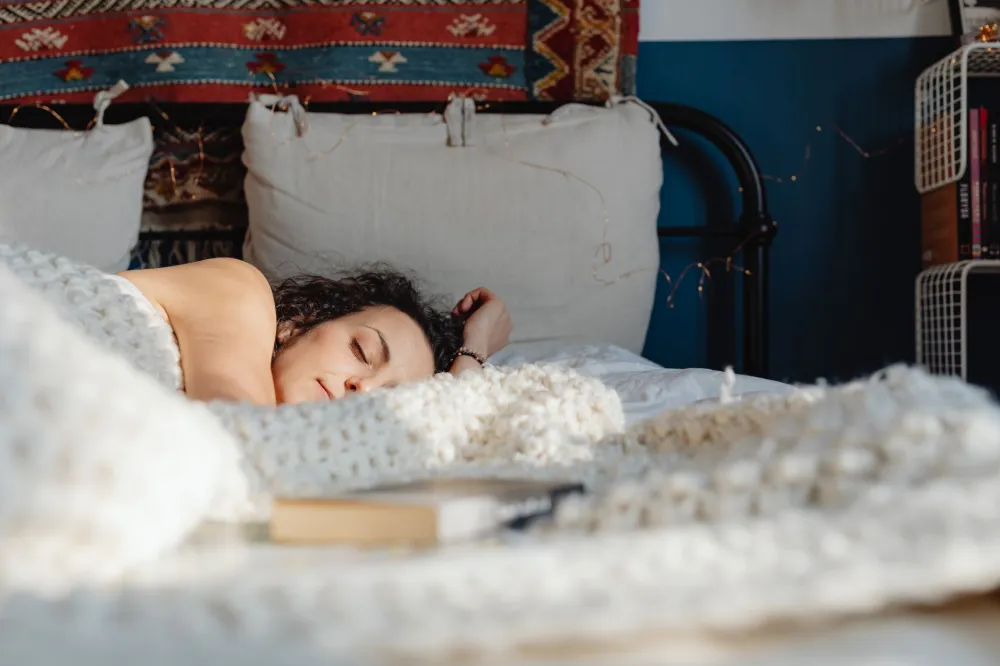 Person sleeping deeply in a dark bedroom to recover from keto flu exhaustion