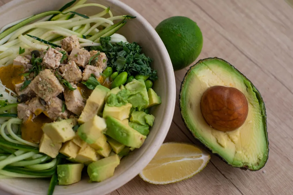Fresh salmon fillet beside sliced avocado, both key ketogenic diet foods for healthy fats