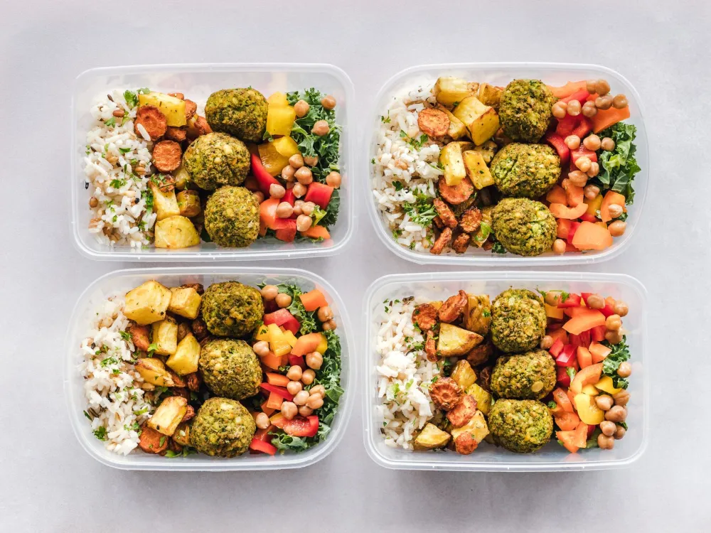 Keto meal prep containers with grilled chicken, greens, and eggs ready for the week