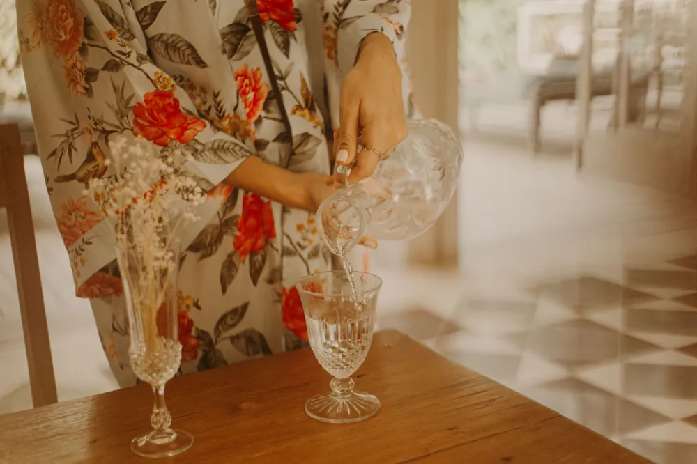 Woman drinking a glass of water in her kitchen to avoid keto mistakes like dehydration