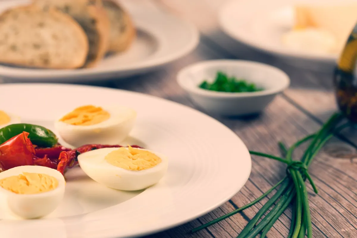 Avocado, eggs and leafy greens on a plate, a balanced fix for common keto mistakes