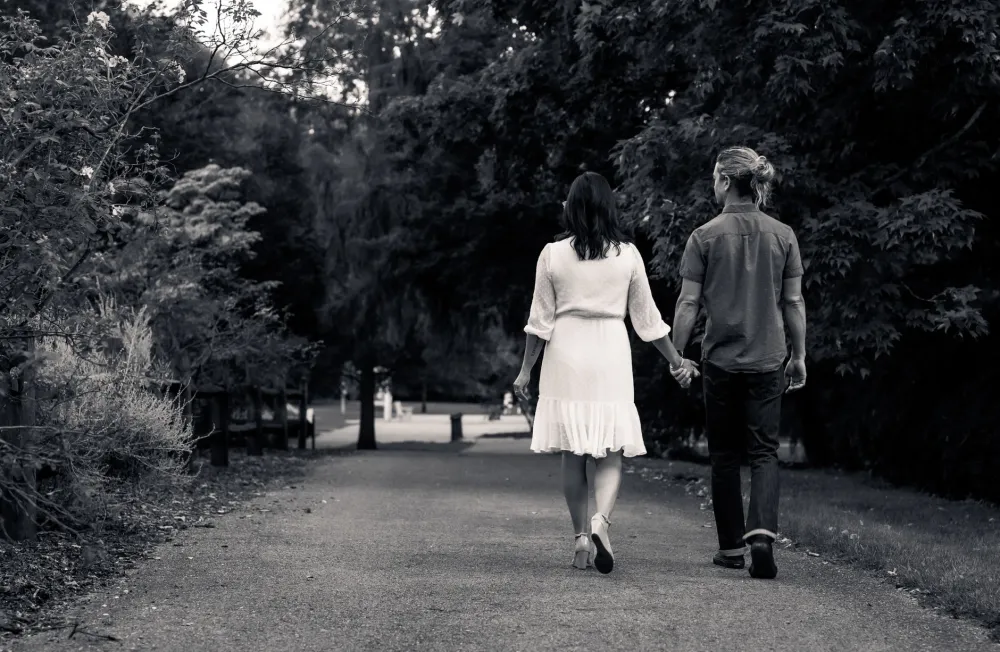 Couple walking in a green park, adding gentle movement to support weight loss