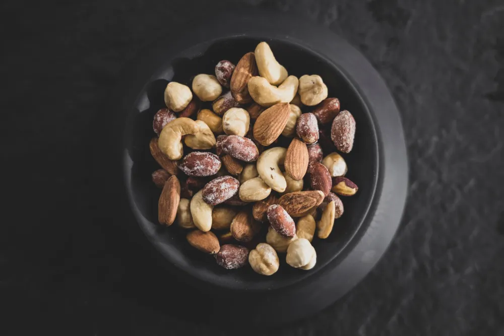 Small bowl of pecans, almonds and macadamia nuts portioned for a low-carb snack