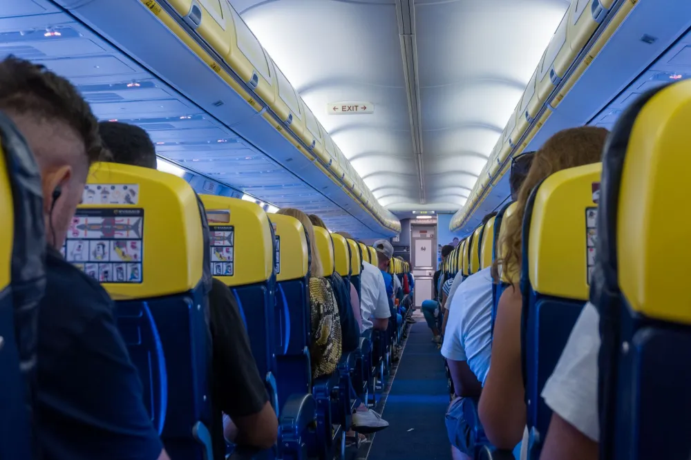 Airplane passenger stretching legs in aisle to reduce leg swelling on long flights