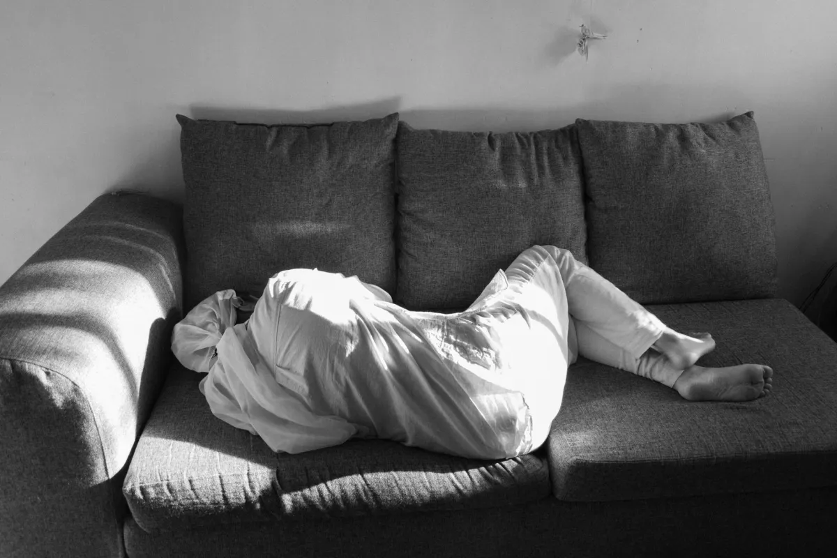 Person resting with feet raised on sofa pillows to ease mild leg edema