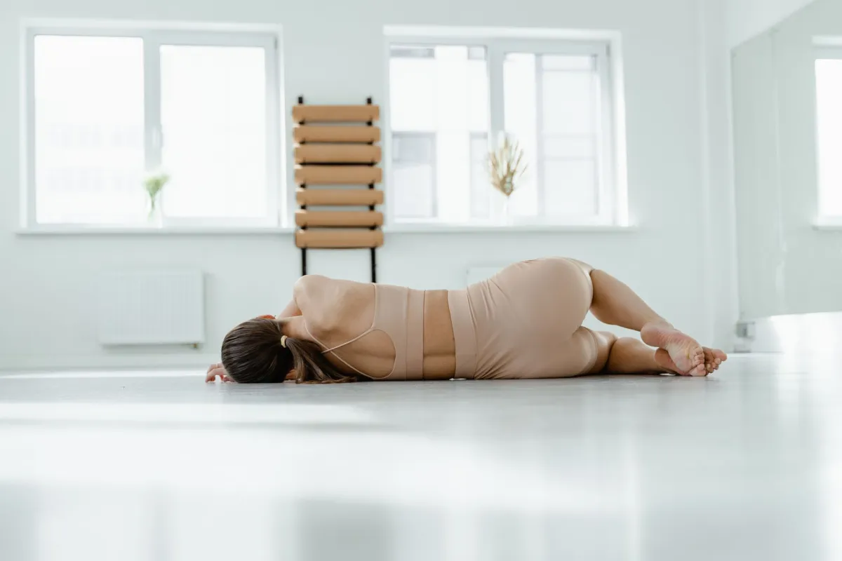 Woman doing a lower back stretch on a yoga mat at home for pain relief
