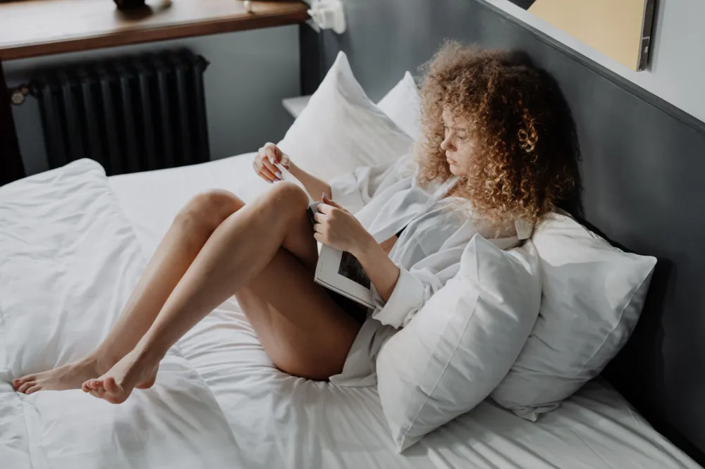 Person resting with a swollen leg propped up on pillows on a sofa