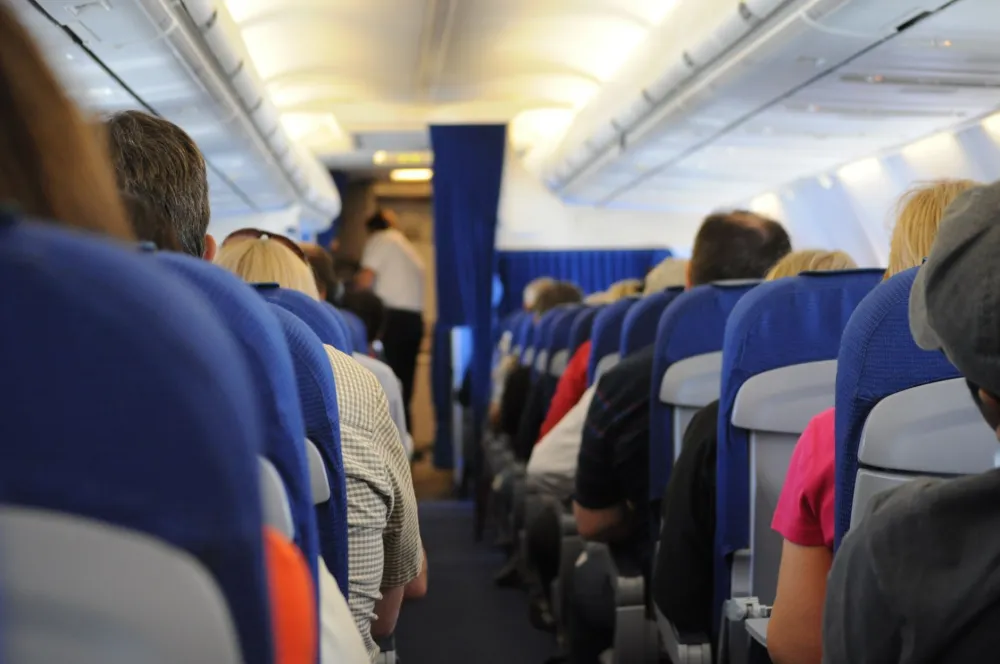 Airplane passenger stretching legs in the aisle to lower blood clot risk