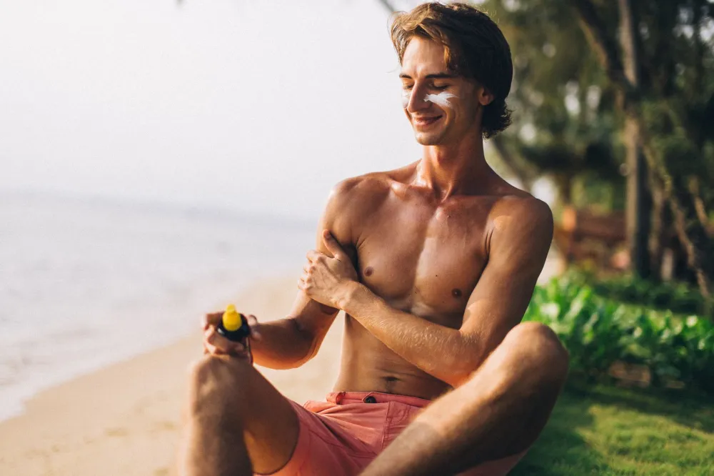 Perky Breasts Naturally: Simple Habits vs Overhyped Fixes 4 Woman applying sunscreen to her chest to protect skin collagen from sun damage