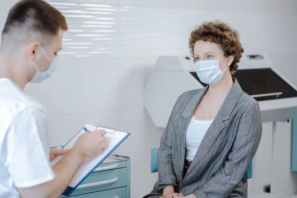 Perky Breasts Naturally: Simple Habits vs Overhyped Fixes 5 Woman talking with her doctor about breast changes during a routine checkup